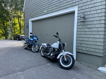 Two cruiser motorcycles parked outside the White Sails Inn garage